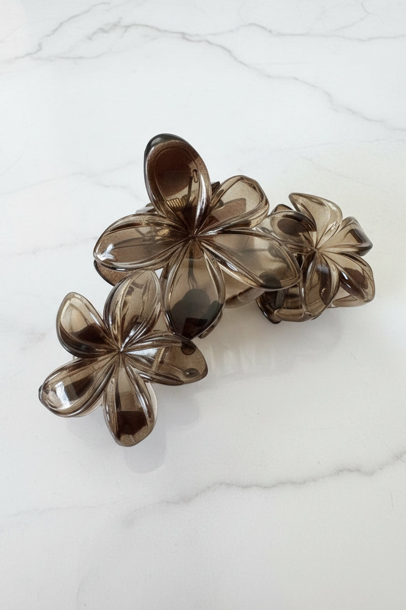  grote smokey bruine bloemen haarklem close up op een marmerkleurige achtergrond
