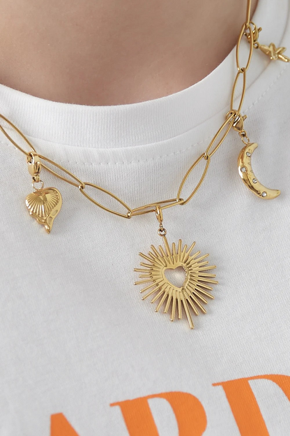 Gouden zon hart bedel bevestigd aan een schakelketting van roestvrij staal.