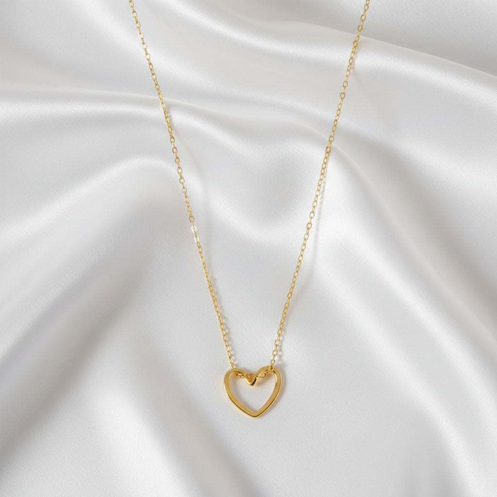 “Goudkleurige hart ketting van stainless steel op satijnen achtergrond”