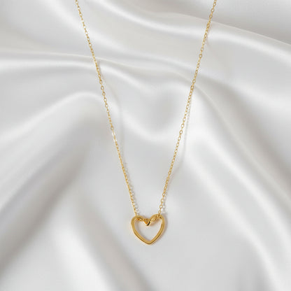 “Goudkleurige hart ketting van stainless steel op satijnen achtergrond”