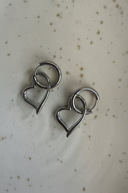 Set zilveren hart hangers met handige kliksluiting op een lichte ondergrond.