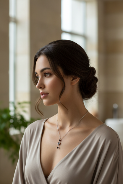 Model draagt zilverkleurige ketting met zwart kristal hartje