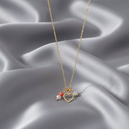 Kinderwens ketting met hartje, rozenkwarts, carneool en maansteen op grijs satijnen kleed.