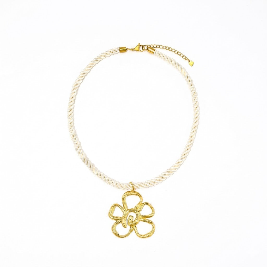 Witte koordketting met gouden bloemhanger.