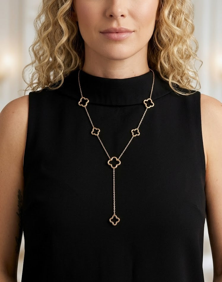 Een close-up van een vrouw met blond haar die de goudkleurige Glow Mystic-hanger met zes klavers draagt, ideaal voor een chique en tijdloze look.