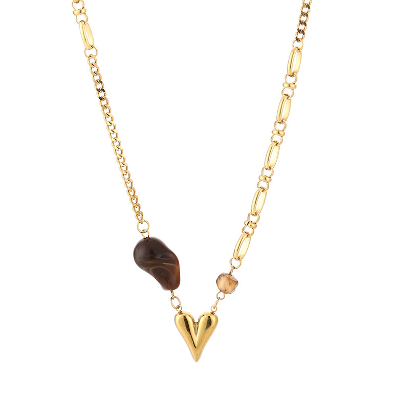 Overzicht van de gouden asymmetrische ketting met bruine kraal en gouden hart op witte achtergrond