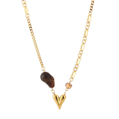 Overzicht van de gouden asymmetrische ketting met bruine kraal en gouden hart op witte achtergrond