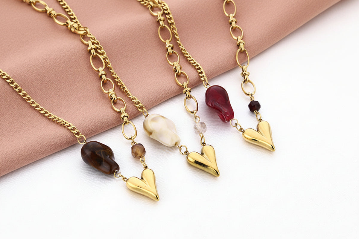 Glow Mystic in Style goudkleurige stainless steel ketting met bruine kraal en goud 3D hartje naast andere varianten