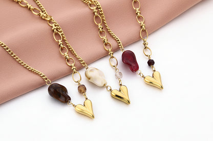 Glow Mystic in Style goudkleurige stainless steel ketting met bruine kraal en goud 3D hartje naast andere varianten