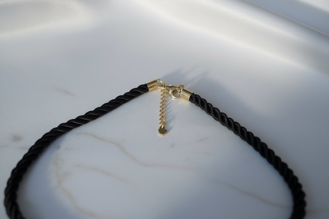 Zwarte statement ketting met goudkleurige bloemhanger voor dames.
