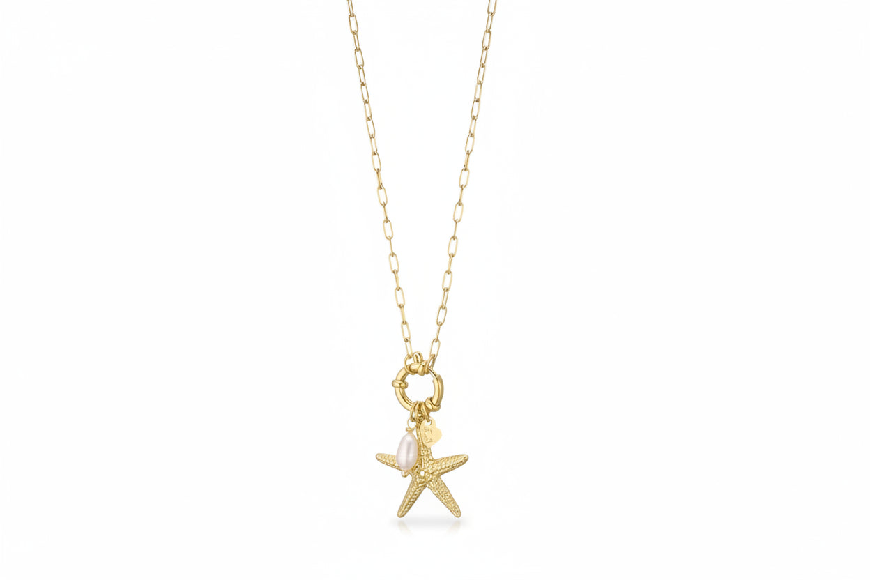 Goudkleurige stainless steel ketting van Glow Mystic met een gedetailleerde zeester-bedel en een echte witte zoetwaterparel, hangend aan een grove schakelketting met voorsluiting.
