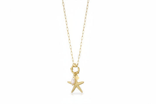 Goudkleurige stainless steel ketting van Glow Mystic met een gedetailleerde zeester-bedel en een echte witte zoetwaterparel, hangend aan een grove schakelketting met voorsluiting.