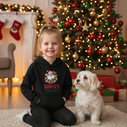 Child wearing black Santa's Little Helper Kids Hoodie with festive Santa design outdoors in snowy forest