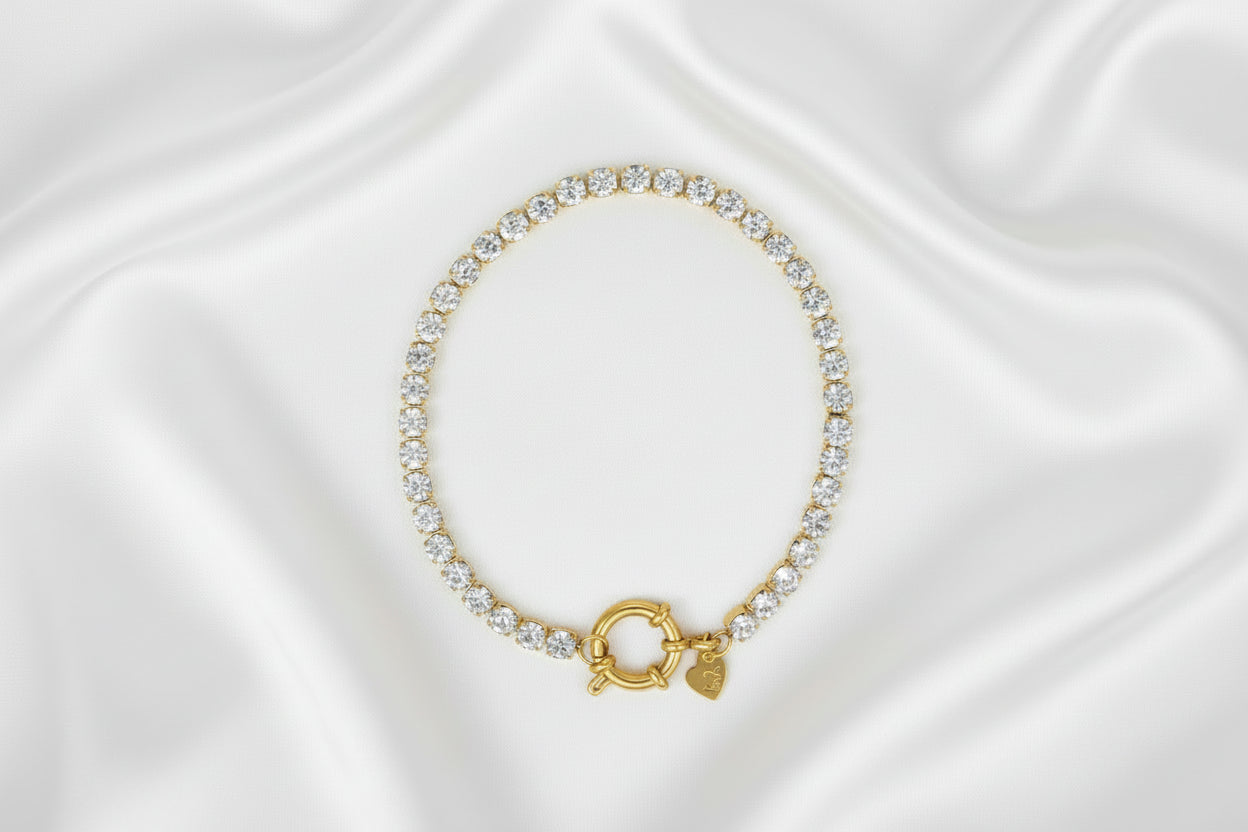 Gouden armband met sprankelende kristallen gepresenteerd op een marmeren ondergrond 