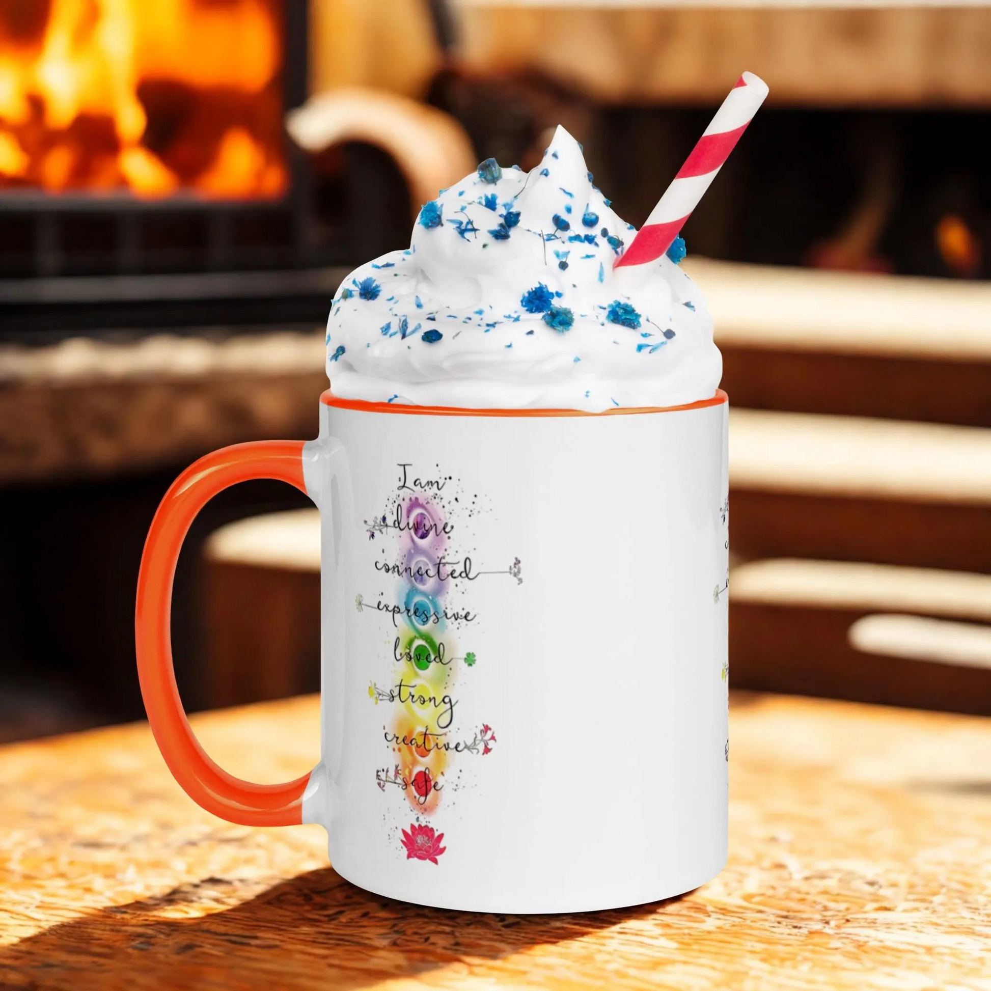 Motivation Chakra Mug with vibrant chakra design, orange handle, filled with whipped cream and blue sprinkles, cozy background