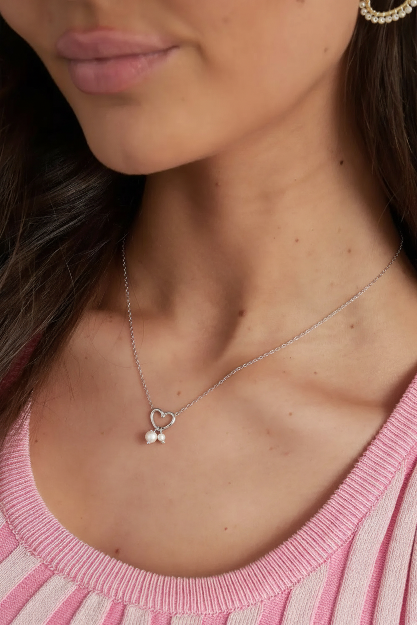 Model draagt minimalistische zilverkleurige ketting met hartje...