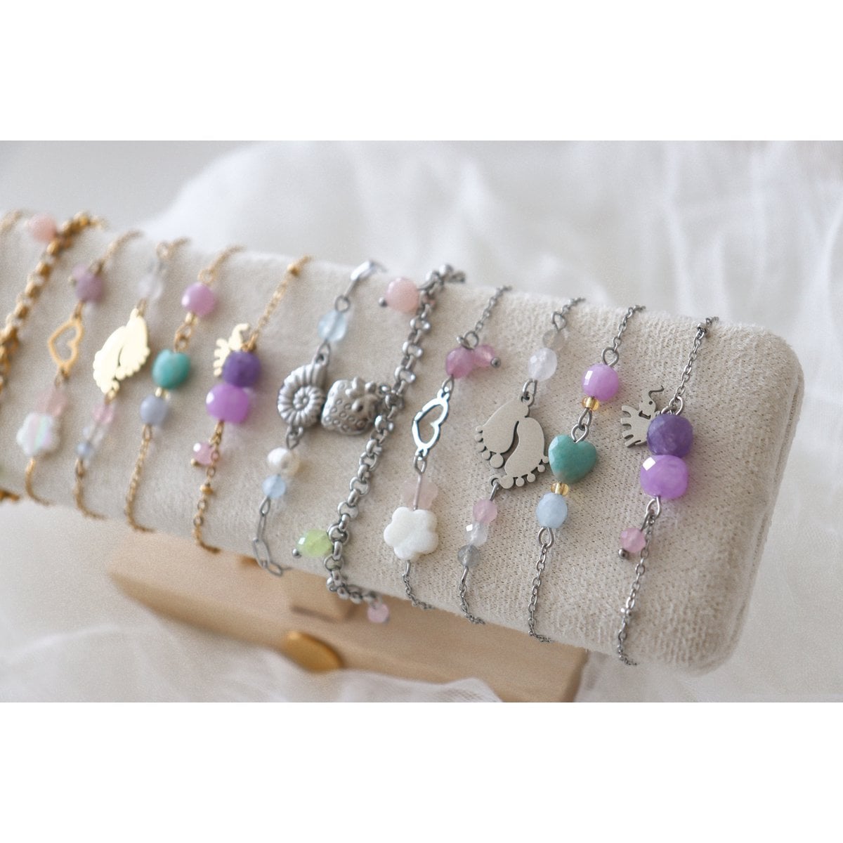 Sfeerimpressie van het zilverkleurige Geluksarmbandje met Olifantje op een sieradendisplay, omringd door andere fijne edelsteenarmbanden uit de spirituele collectie.