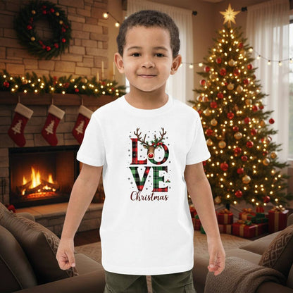 young boy wearing white organic kids t-shirt with love christmas design in festive living room