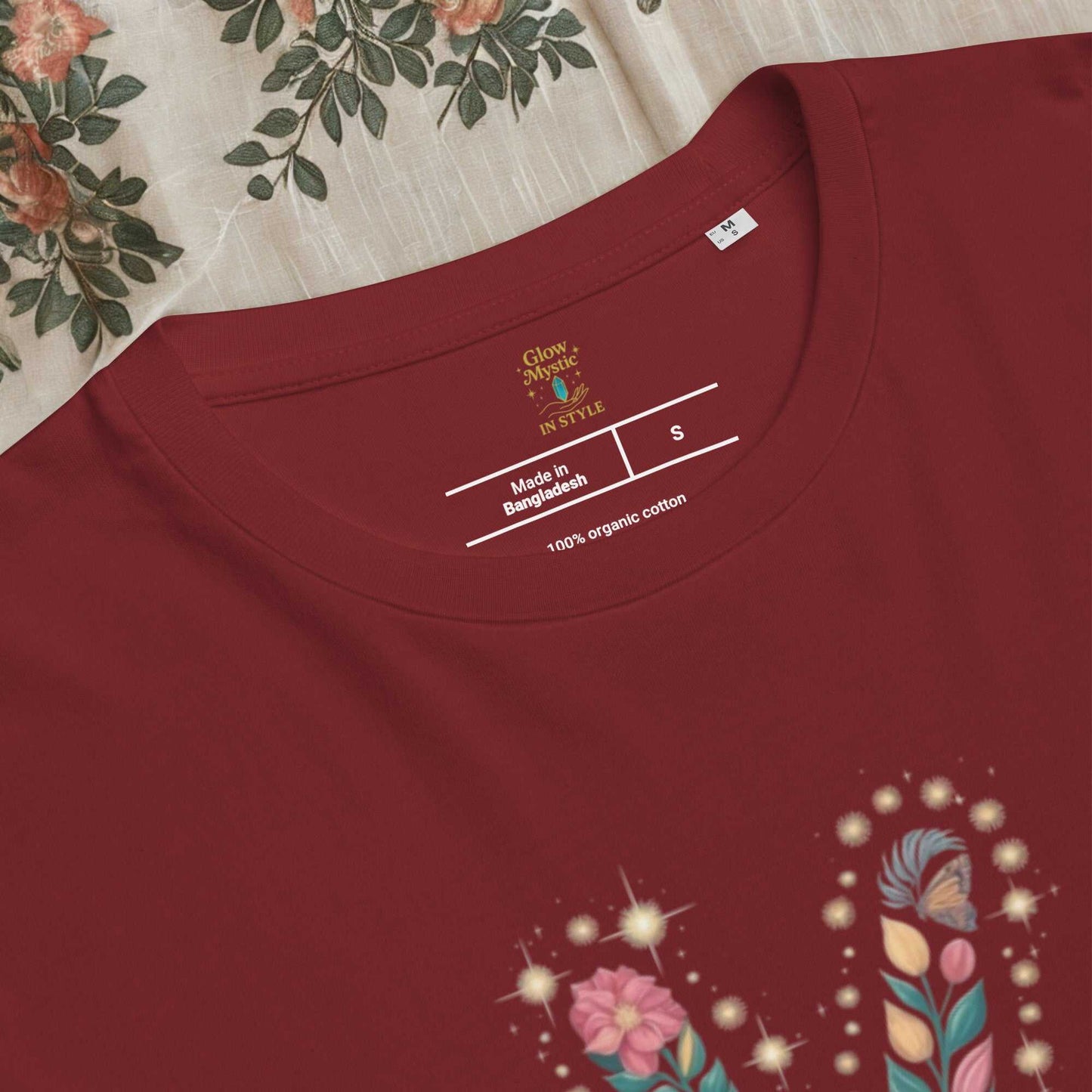 Close-up of a maroon unisex organic cotton t-shirt with floral design and printed label inside neckline