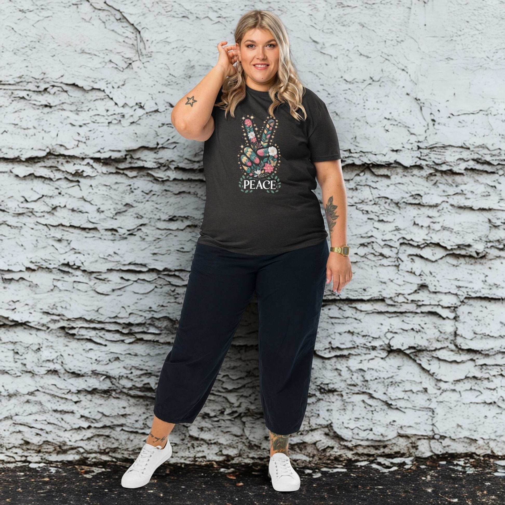 plus size woman wearing black unisex organic cotton t-shirt with peace hand sign design and black pants against textured wall background