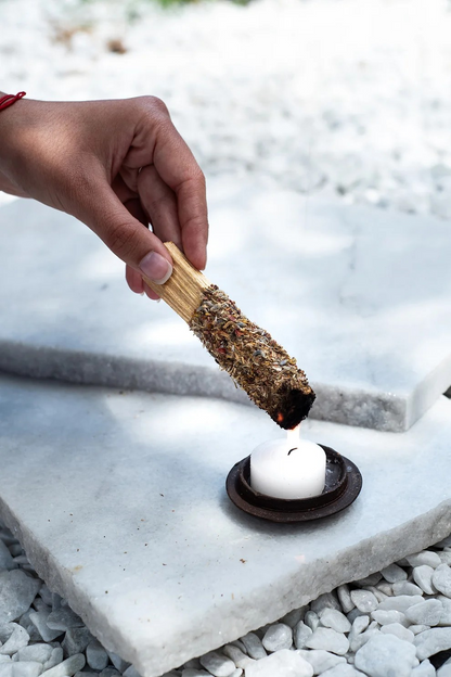 Het aansteken van het Sagrada Madre Palo Santo kruidenstokje bij een kaars