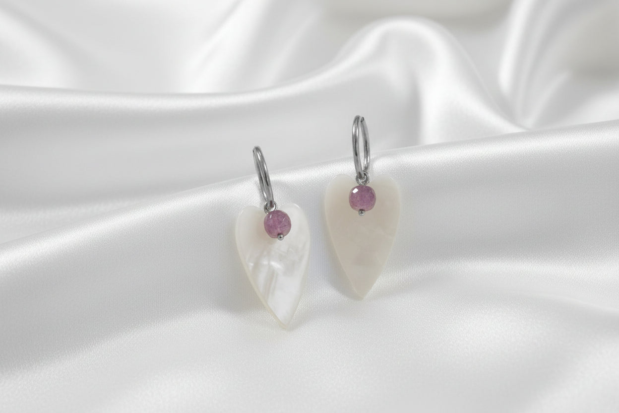 Amethist parelmoer hart oorringen op zijde achtergrond