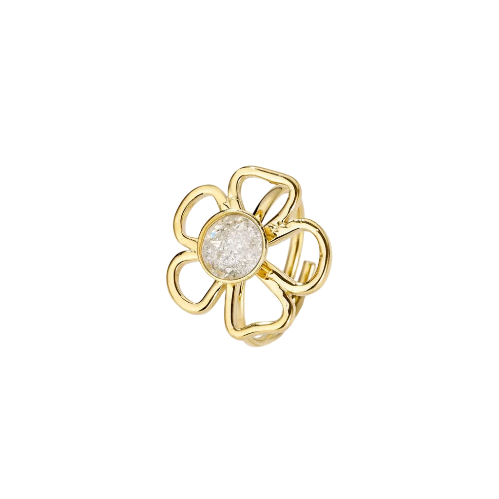 Close-up van de goudkleurige bloemenring met een centrale witte steen op een witte achtergrond, wat het verfijnde design benadrukt."