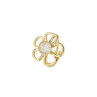 Close-up van de goudkleurige bloemenring met een centrale witte steen op een witte achtergrond, wat het verfijnde design benadrukt."