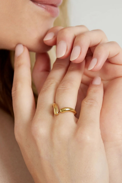 Model draagt gouden verstelbare organische ring aan de hand