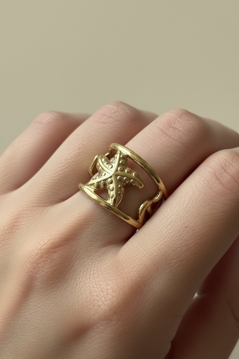 "Duidelijke close-up foto van de goudkleurige RVS Starfish ring van Glow Mystic in Style. Het gedetailleerde ontwerp van de zeester is goed zichtbaar."