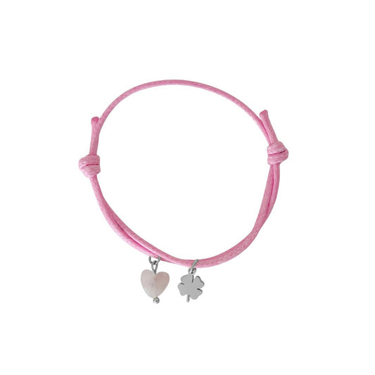 Studiofoto van een roze waxkoord armbandje met een Rozenkwarts hartje en een goudkleurig klavertje vier bedeltje, op een witte achtergrond."