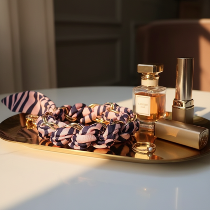 Glow Mystic in Style zebra gestreepte telefoonkoord met gouden details op een goudkleurige schaal met lifestyle producten eromheen.