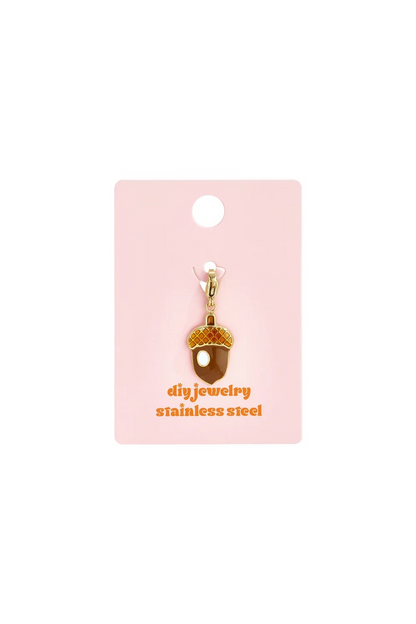 Gouden RVS eikel bedel met emaille op roze sieradenkaartje