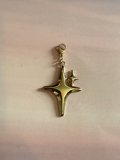 Luxe gouden RVS ster bedel van stainless steel voor ketting op gekleurde achtergrond.