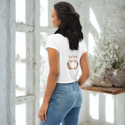 Woman wearing white High Heels High Vibes Crop Top with graphic and blue jeans standing indoors