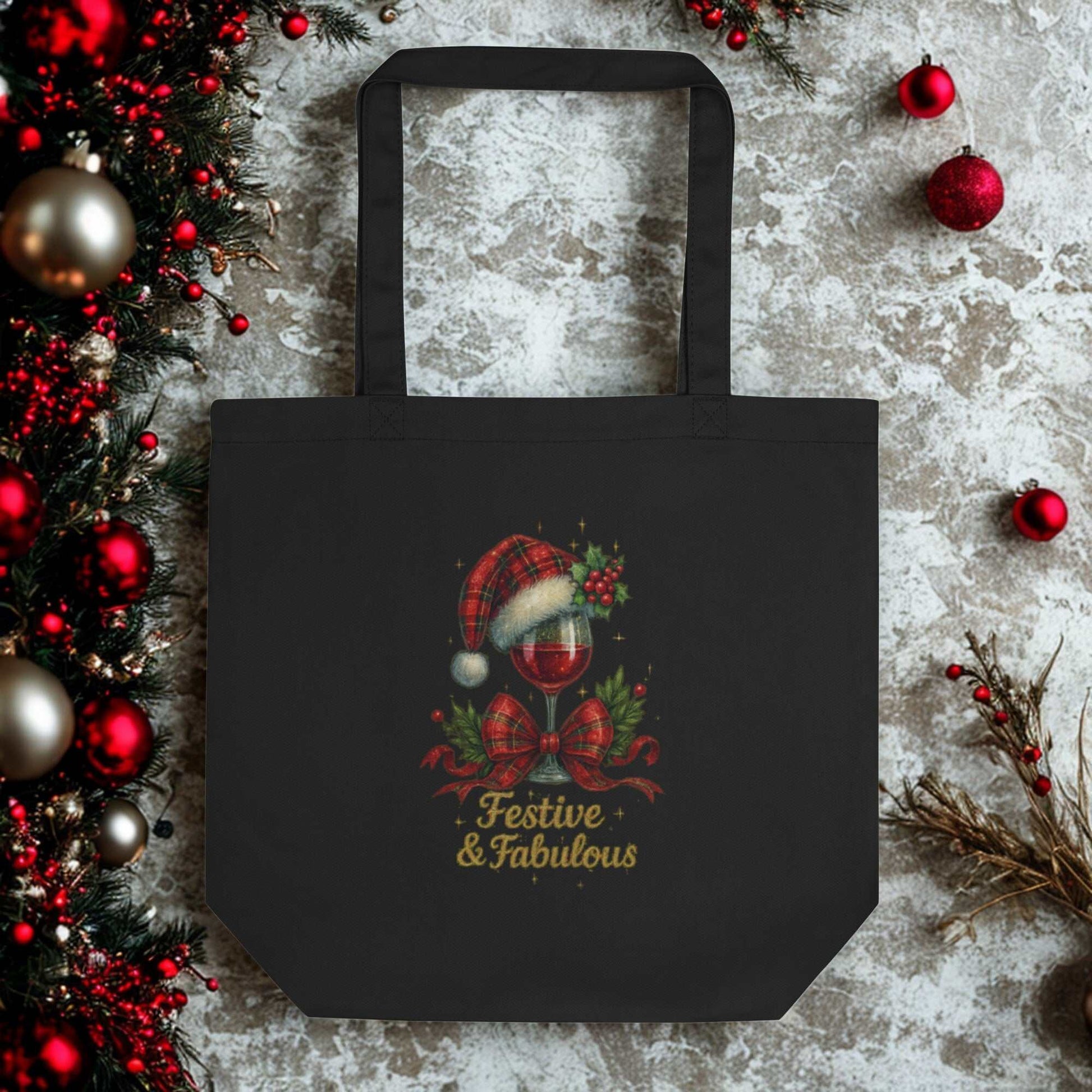 Black Eco Tote Bag with festive "Festive & Fabulous" holiday design featuring a Santa hat and holly decor, made of eco-friendly organic cotton
