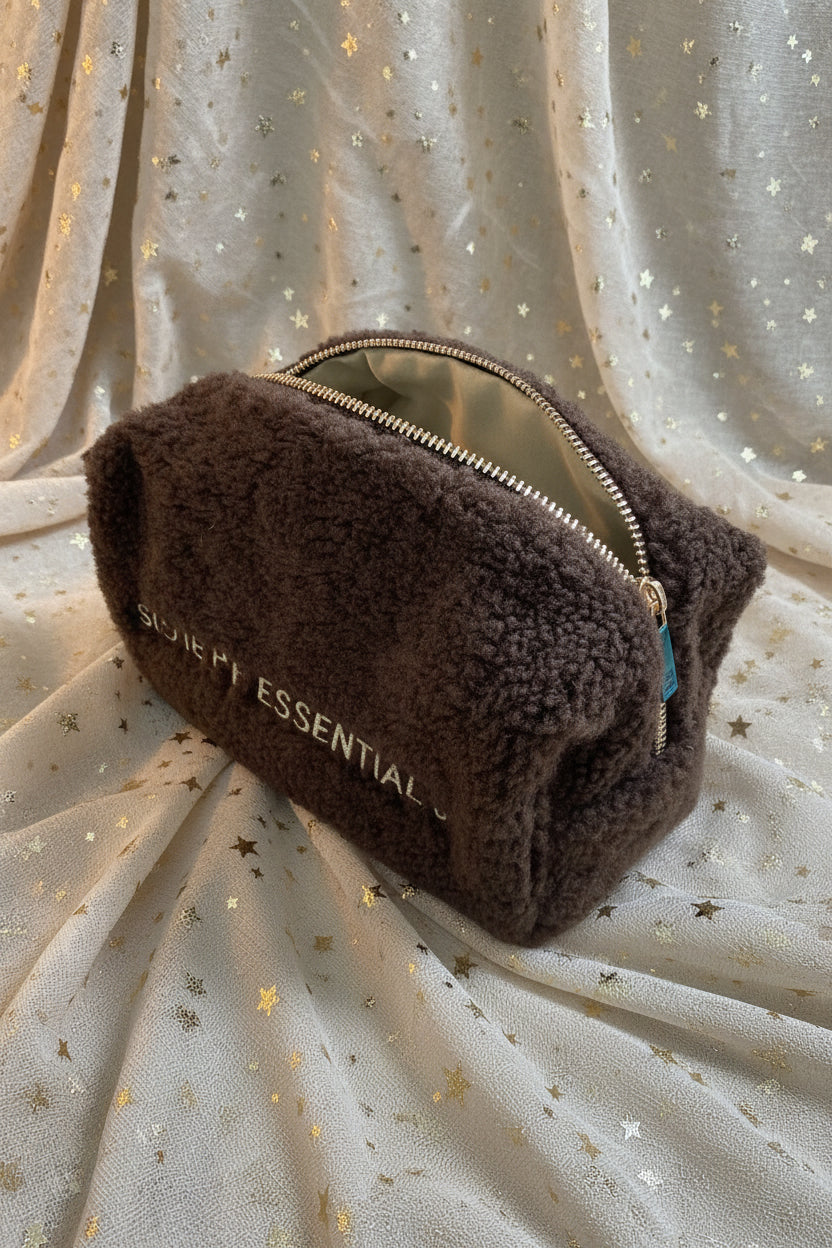 Zijaanzicht van het Glow Mystic in Style zachte teddy make-up tasje in donkerbruin met gouden ritssluiting