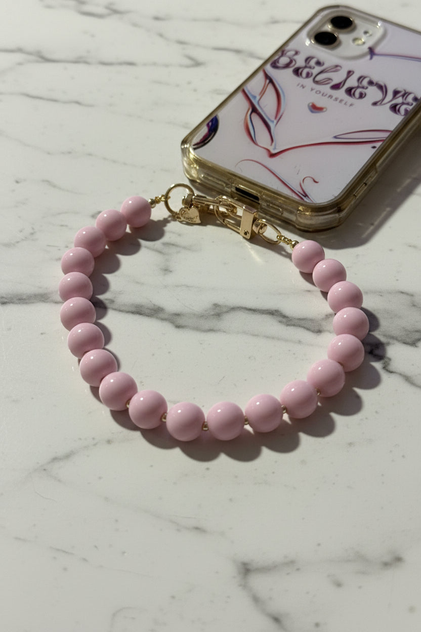"Luxe lifestyle foto op marmer van de Soft Pink phone charm. De goudkleurige tussenballetjes glimmen prachtig in het licht."