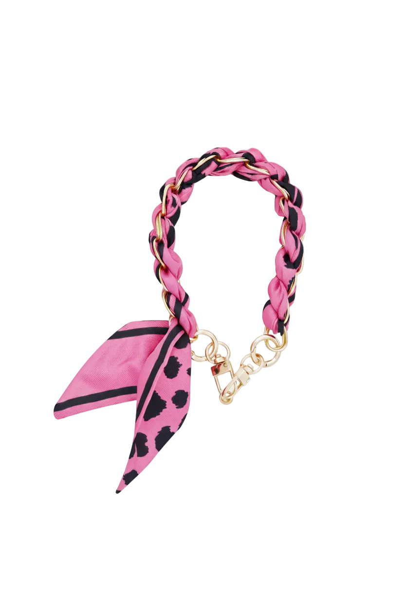 Luxe goudkleurige telefoonketting gevlochten met fuchsia roze stof met panterprint en een geknoopt sjaaltje, inclusief transparant inlegvel op een witte achtergrond.