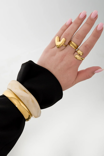 Tijdloze gouden RVS bangle armband met minimalistisch design gedragen door een model.