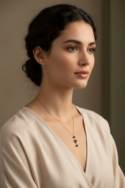Vrouw draagt een elegante gouden ketting met zwart kristal hartje en zwarte toermalijn edelstenen.