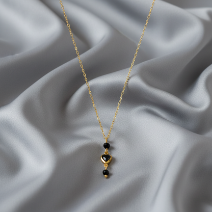 Gouden ketting met zwart kristal hartje en facet geslepen zwarte toermalijn edelstenen.