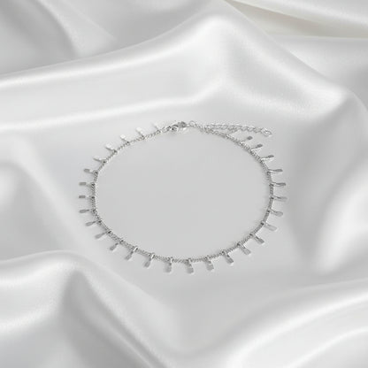 Zilver en goudkleurige trendy enkelbandjes naast elkaar op satijnen ondergrond