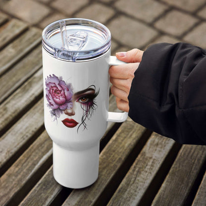 White floral face travel mug with artistic feminine design and clear plastic lid and straw held by a hand on wooden bench outdoors