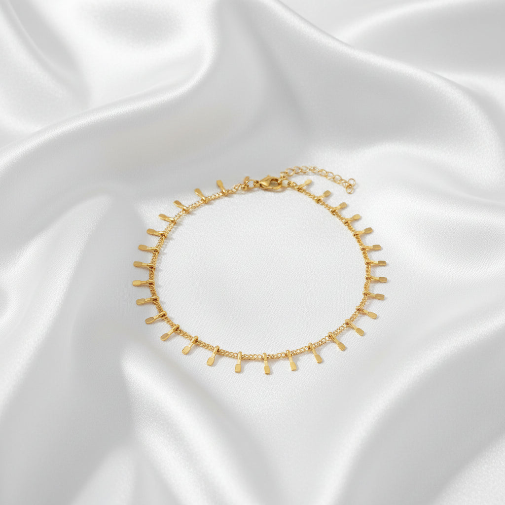 Goudkleurig trendy enkelbandje op zachte satijnen ondergrond