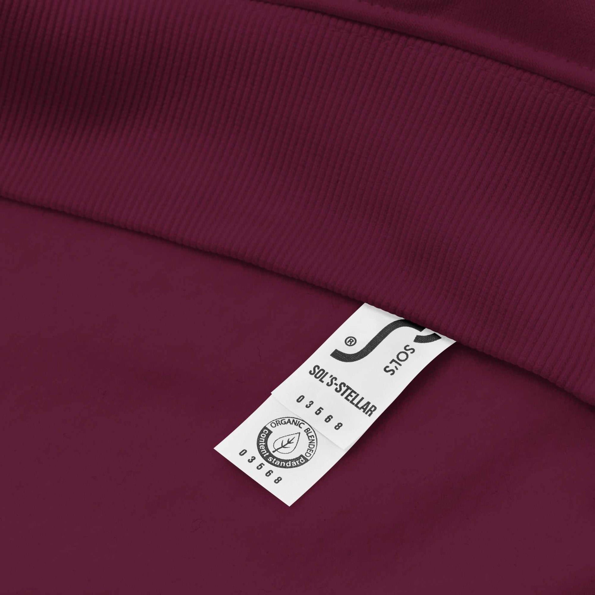 Close-up of maroon Glow Mystic in Style Hoodie showing organic cotton fabric tag and ribbed hem detail