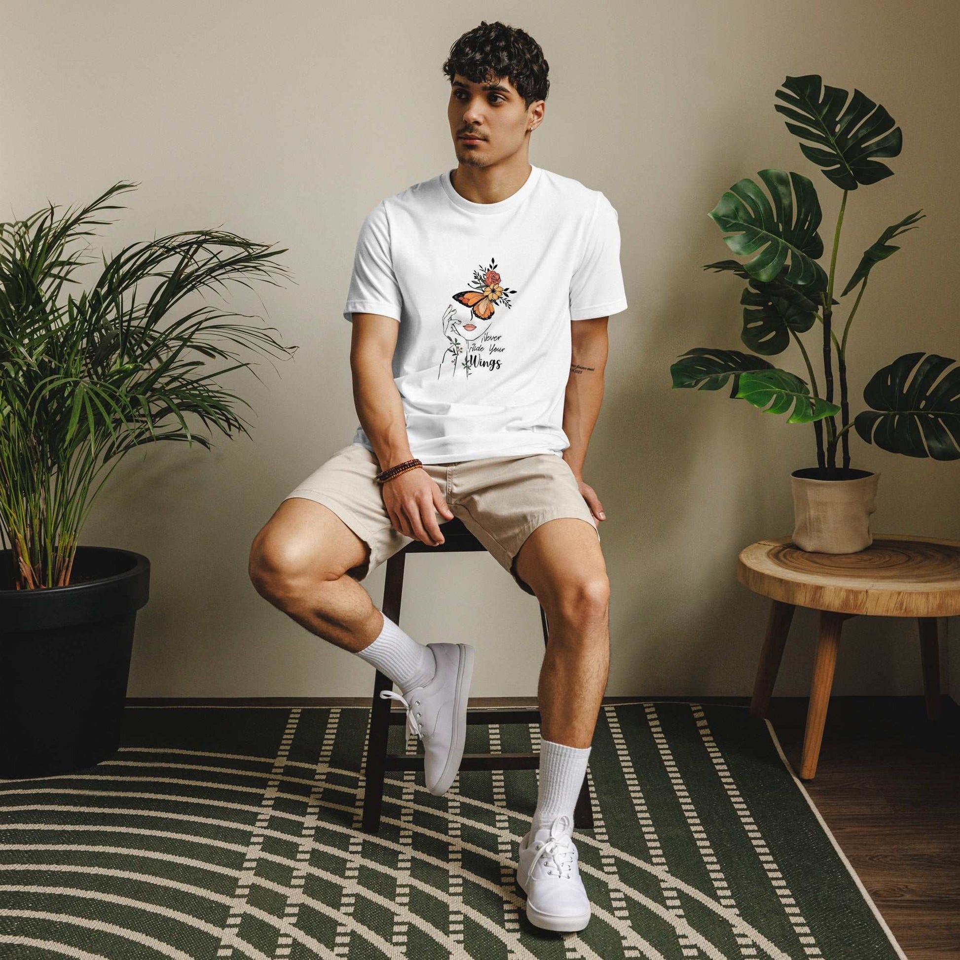 Man wearing Butterfly Graphic Organic Cotton T Shirt with nature-inspired design sitting indoors