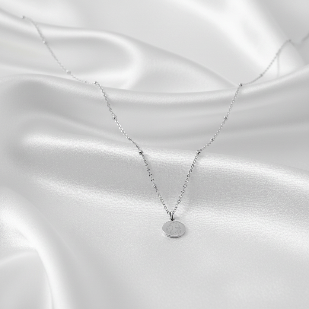 “Vriendinnen ketting zilver met ronde bedel op satijnen achtergrond”