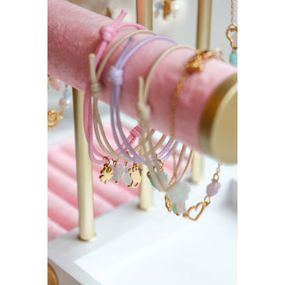 "Close-up van een collectie waxkoord armbandjes met goudkleurige bedels, stijlvol bij elkaar gefotografeerd."