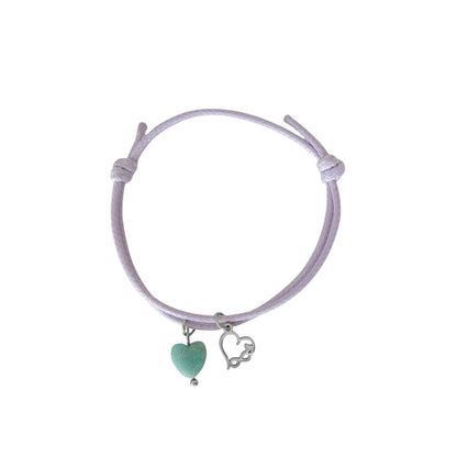 "Studiofoto van een lila waxkoord armbandje met een Amazoniet hartje en een zilverkleurig infinity-hart bedeltje op een witte achtergrond."